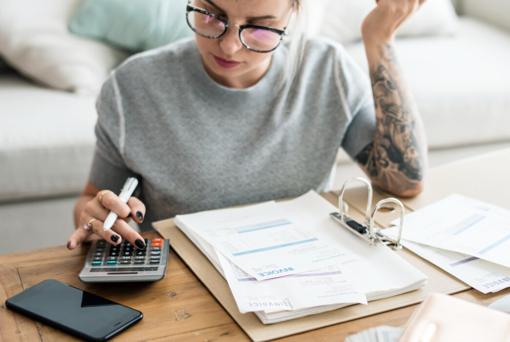 Person, die ihre Finanzen ordnet, ein Budget plant und smarter spart, um finanzielle Freiheit zu erreichen.